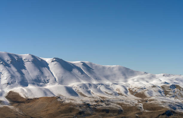 snow-capped Montefeltro mountains in the warm light of sunset against the cloudy sky