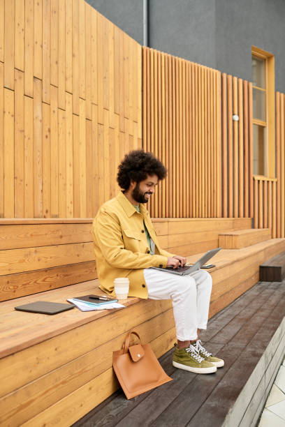 istock Working on Laptop While Sitting on Wooden Steps Outside 2191255857