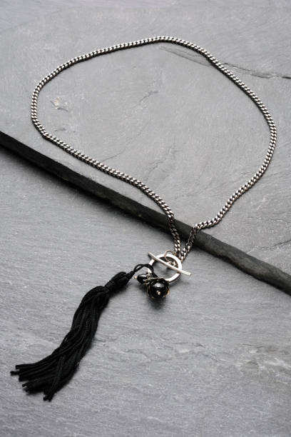 istock Chain necklace with black stone gem on a black slate 2191258044