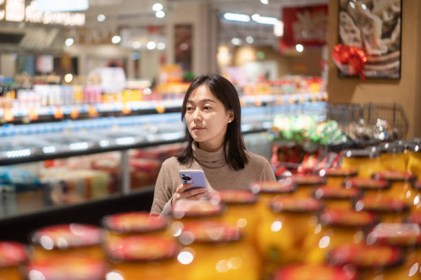 istock asian female using smart phone in supermarket 2191263922