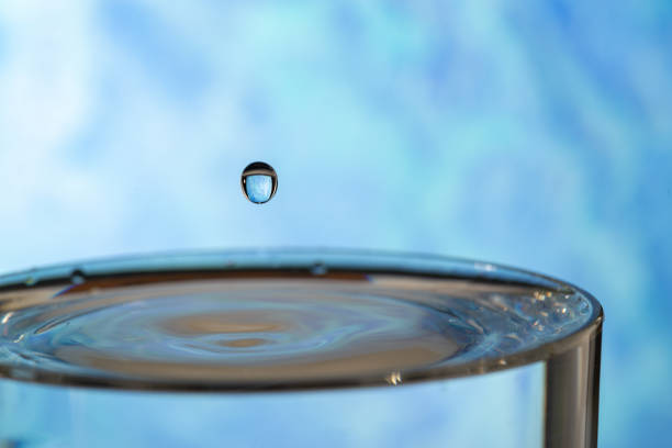Water drop splashing on the surface of the water in a blue background.