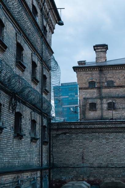 istock Twoo vehicles sit outside an old brick building with barbed wire 2191269883