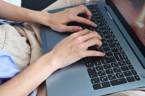 istock A woman using her laptop on sofa cross-legged for working from home. 2191270188