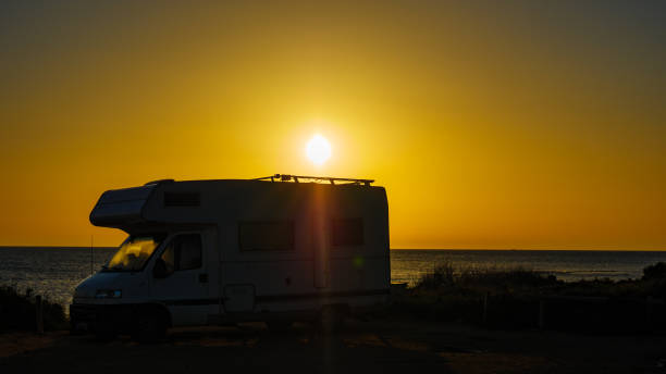istock Camper car on beach at sunrise 2191271998