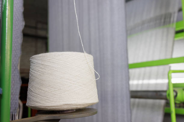bobbin of white woolen threads in production, weaving machine, cotton mill
