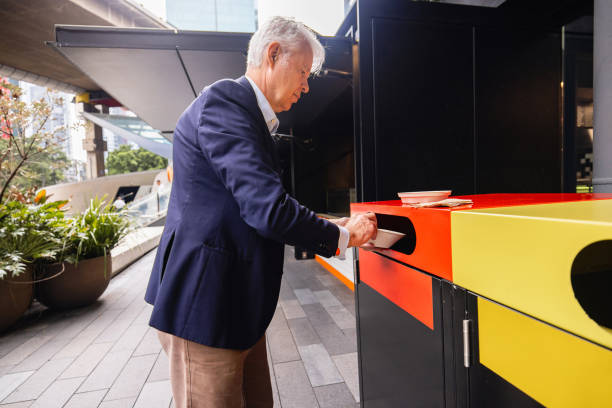 istock Senior Caucasian man separating garbage into different containers after finishing his lunch break 2191274090