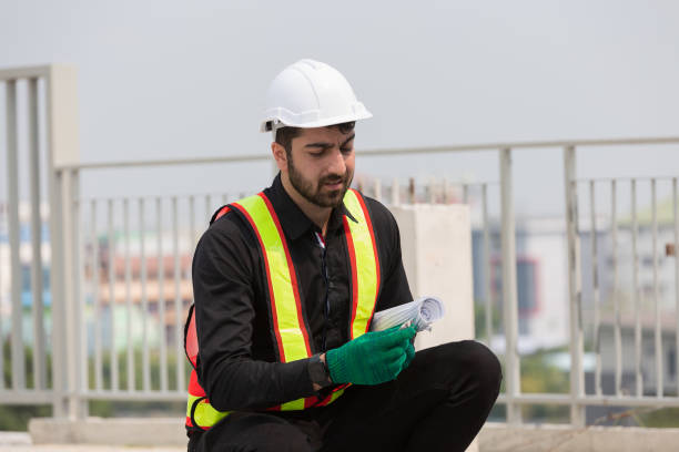 istock Male foreman builder working at construction site. Male engineer inspecting work at construction site, wearing safety uniform, helmet 2191280535