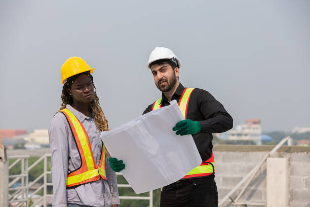 istock Male and female construction engineer worker working with blueprint at construction site 2191280549