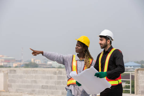 istock Male and female construction engineer worker working with blueprint at construction site 2191280554