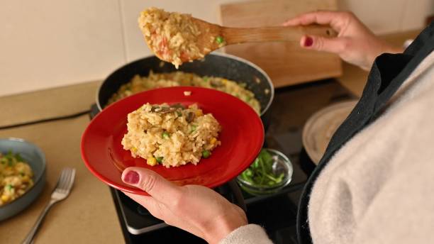 istock Serving Vegetarian Paella on a Red Plate: A Delicious Spanish Cuisine Experience 2191287939