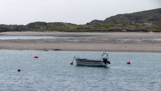istock A boat moored in shallow water. Sandy beach. White boat on water 2191291308