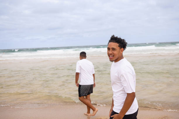Two brothers, Pacific Islanders, having fun spending time together on the beach.