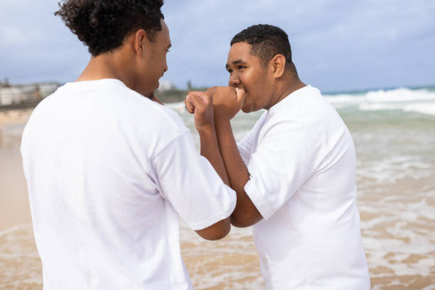two Latin best friends men having fun at beach in Acapulco Mexico Latin America, hispanic young people in pacific ocean