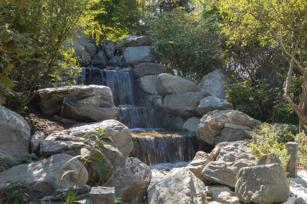 istock Krasnodar Japanese Garden. Three-stage cascading waterfall in an artificial stone river bed. Huge boulders are naturally scattered along the river bed. Park 