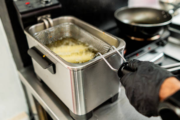Close-up of a man frying spring roll on commercial kitchen