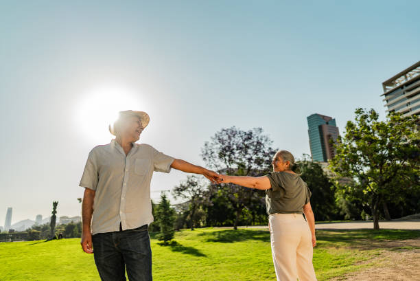 istock Senior couple walking holding hands in a public park 2191295679