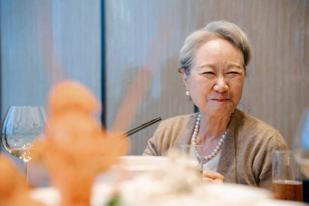 istock Asian senior woman attending dinner party 2191297599
