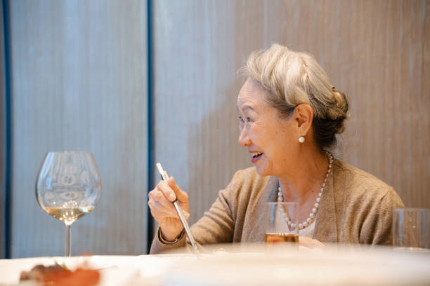 istock Asian senior woman attending dinner party 2191297744