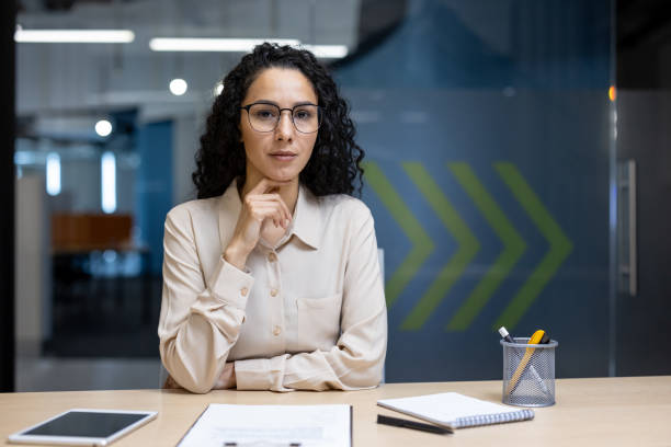 istock Confident hispanic businesswoman sitting in modern office with tablet and notepad, ready for meeting 2191298032