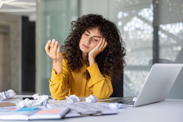 istock Frustrated office worker struggling with paperwork at her desk 2191298267