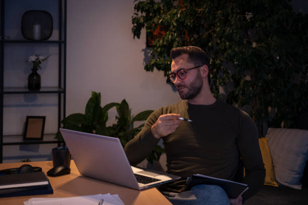 istock Focused businessman working late at night from home using laptop computer 2191300352
