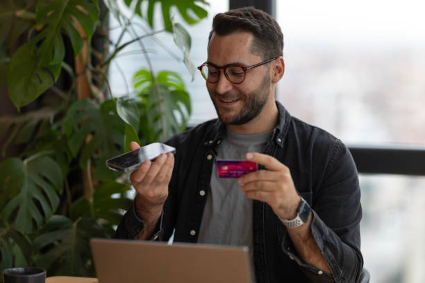 istock Young man making online payment using smartphone and credit card 2191300682