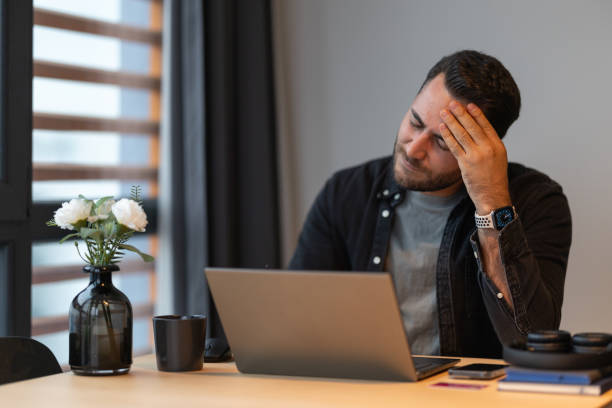 istock Stressed businessman suffering from headache while working on laptop 2191300754