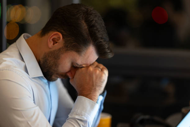 istock Stressed businessman rubbing his eyes while working late at night in the office 2191301096