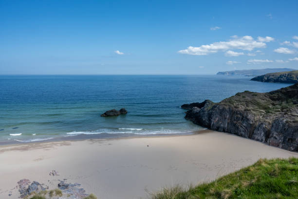 Beautiful image captures Durness Beach, Scotland with soft sand, turquoise waters, dramatic cliffs, and a peaceful atmosphere, showcasing a scenic coastal location in Scotland, perfect for travel and nature photography enthusiasts seeking tranquility and picturesque views.
