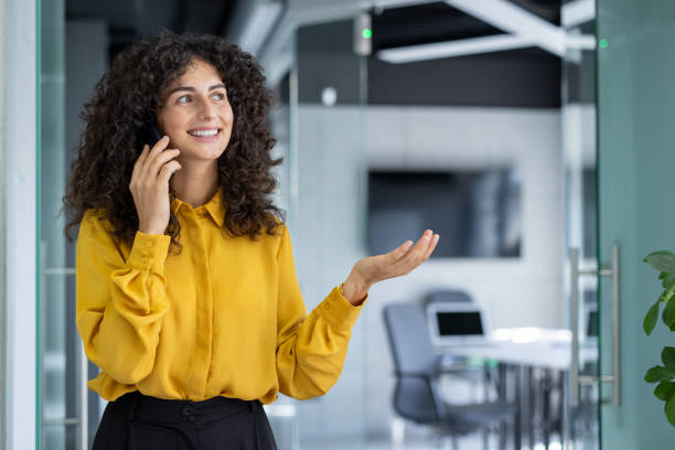 istock Young professional woman talking on phone in modern office setting 2191303277