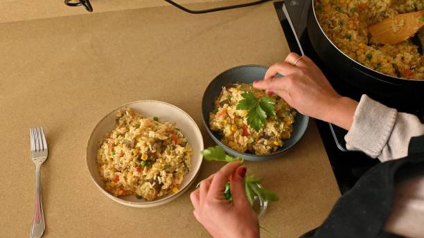 Cooking and Serving Fresh Vegetarian Paella Garnished with Herbs