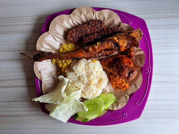 Nasi Lele Bakar, Ayam Bakar Dan Tempe Bakar Dengan Kubis, Mentimun, Sambal Sambel Dan Kriuk Kremes Or Grilled Catfish, Grilled Chicken With Rice, Grilled Tempeh With Cabbage, Cucumber, Chilli Sauce And Crunchy Crispy Flakes. Indonesia Street Food Menu. nasi lele bakar, ayam bakar dan tempe bakar dengan kubis, mentimun, sambal sambel dan kriuk kremes or grilled catfish, grilled chicken with rice, grilled tempeh with cabbage, cucumber, chilli sauce and crunchy crispy flakes. indonesia street food menu.