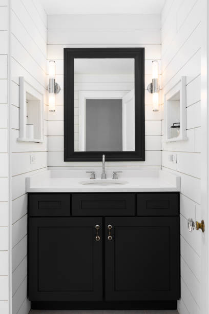 istock A bathroom with white shiplap and a black cabinet and mirror. 2191305124