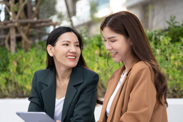 istock Two women smiling and engaging in conversation outdoors, showcasing friendship and connection. setting features greenery, creating relaxed atmosphere 2191306100