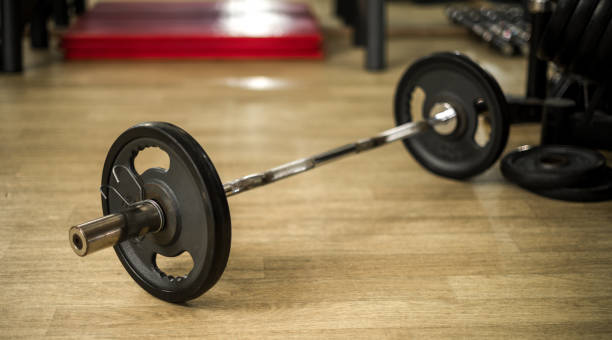 istock Barbell with Weights on Wooden Floor in a Gym Setting 2191306168
