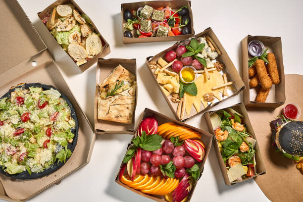 A collection of diverse takeaway meals in eco-friendly cardboard boxes.