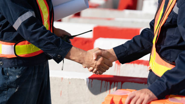 istock Caucasian white civil engineer, architect, or construction worker is wearing a safety suit while inspecting building construction on site and verifying blueprints or drawing plans. 2191308975