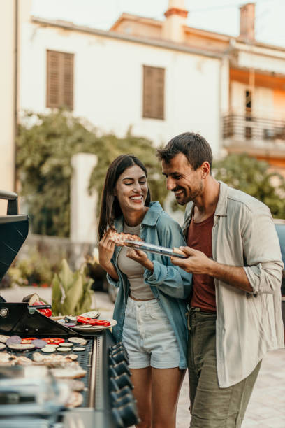 Couple prepare BBQ in the yard