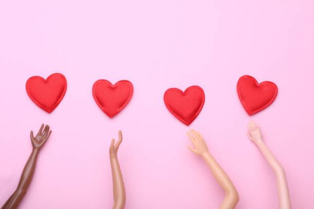 istock Hands of dolls and hearts on pink background 2191312331