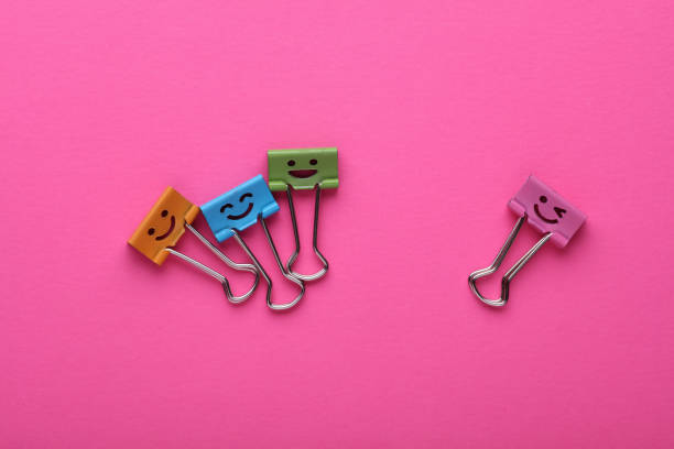 istock Binder clips with a smiling face on pink background 2191312495