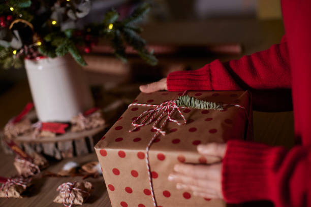 istock female hands holding Christmas gift box at home 2191312627