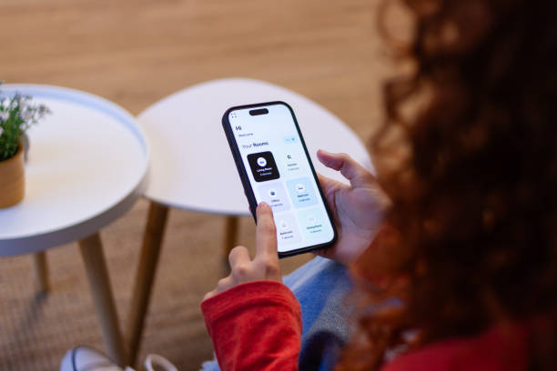 istock Woman using smart home app on mobile phone to control home automation system 2191314296