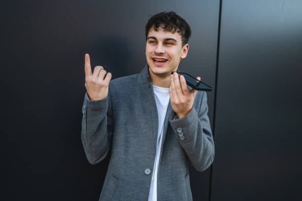 istock young handsome man left voice message on the black wall background 2191316476