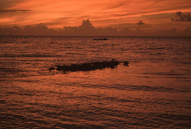 Sunset in the Maldives in the south of Ari Atoll; former known as Ari Beach resort; Dark orange, red colors against light; sun already gone; after golden hour