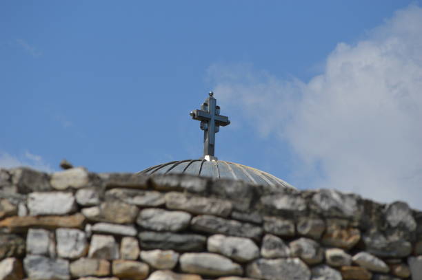a large cross behind a stone fence