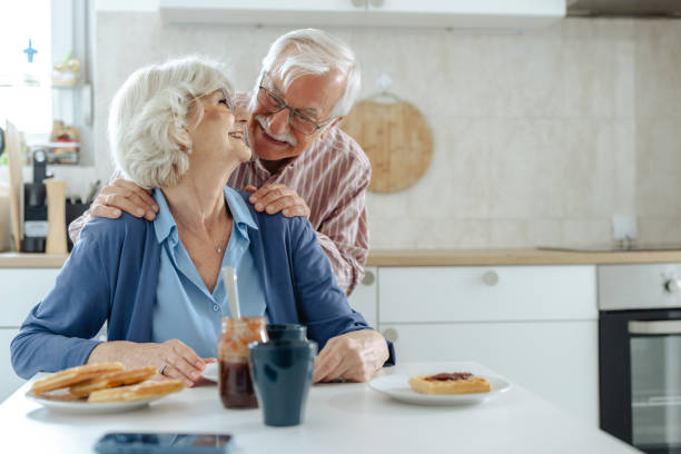 istock Happy senior couple embracing while having breakfast in the kitchen 2191322357