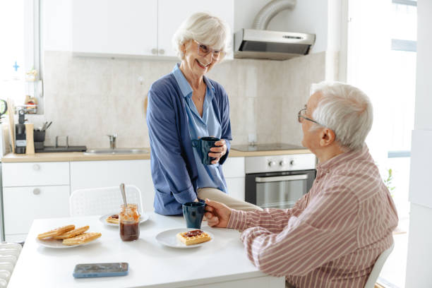 istock Senior couple enjoying coffee and bonding while smiling in their home kitchen 2191322416