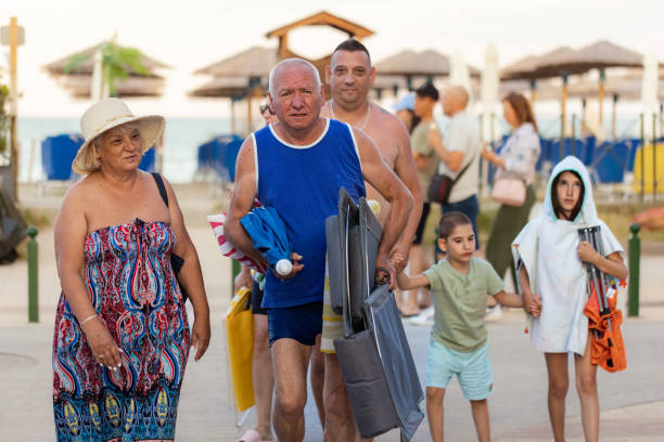 Portrait of a fun-loving family of various ages arrives at the beach.