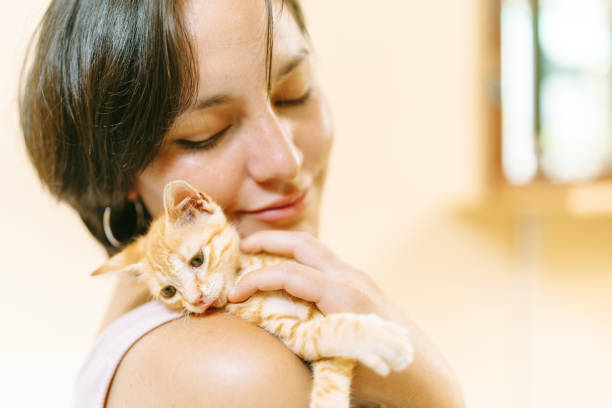istock Young woman cuddling adorable ginger kitten at home 2191323029