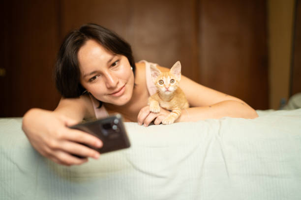istock Young woman taking a selfie with her kitten on the bed 2191323071